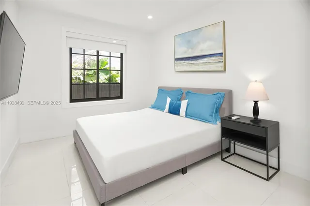 a large bed sitting in a bedroom next to a window