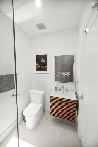 a bathroom with a sink a toilet and mirror