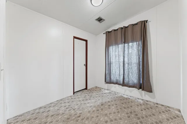 a view of a room with a wooden floor and entryway