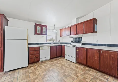a kitchen with granite countertop a refrigerator and a sink
