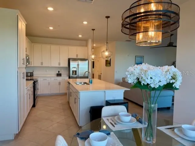 a kitchen with stainless steel appliances granite countertop a stove a sink a refrigerator and a microwave