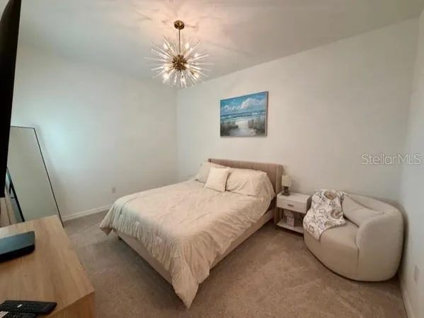 a bedroom with a bed and chandelier