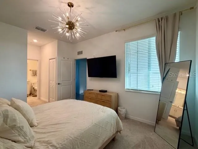 a bedroom with a bed and a flat tv screen on dresser