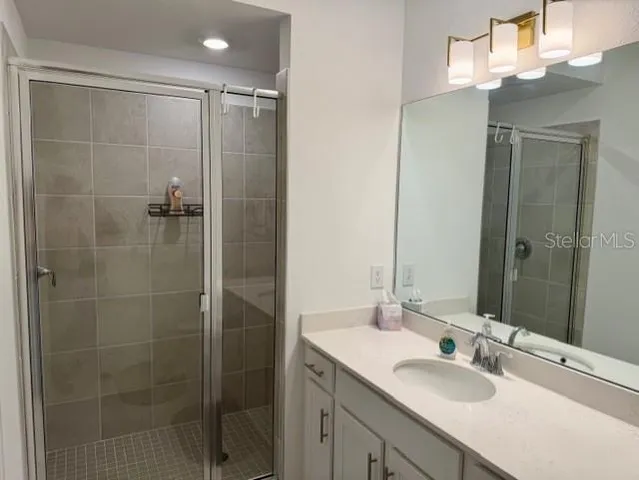 a bathroom with a shower sink and mirror