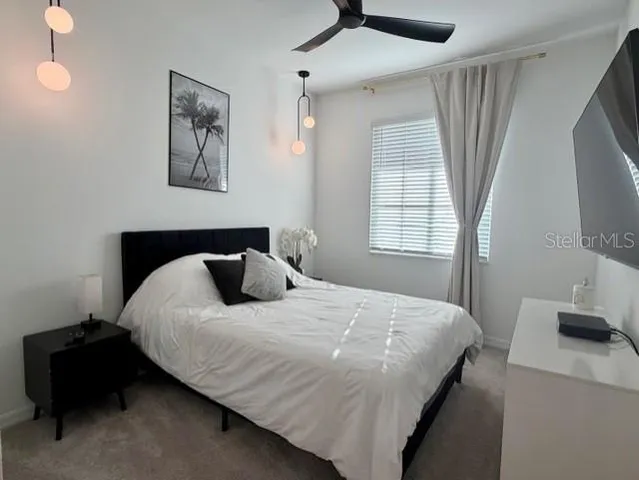 a bedroom with a bed and a flat tv screen on the dresser