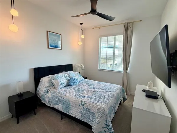 a bedroom with bed and flat tv screen