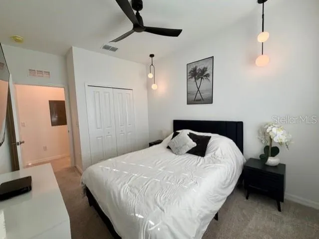 a bedroom with a bed and a flat tv screen on the dresser