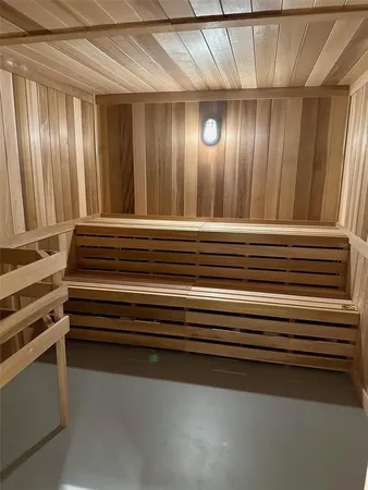 an empty room with wooden floor fireplace and windows