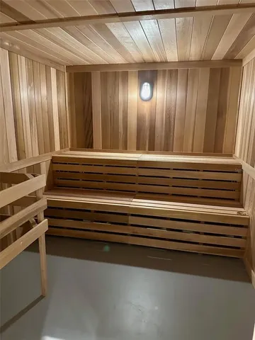 an empty room with wooden floor fireplace and windows