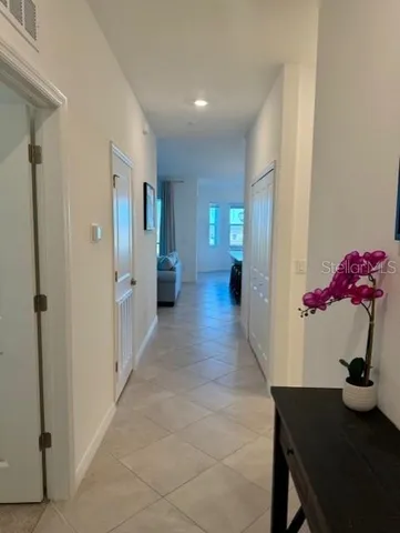 a hallway with a flower pot and a bookshelf