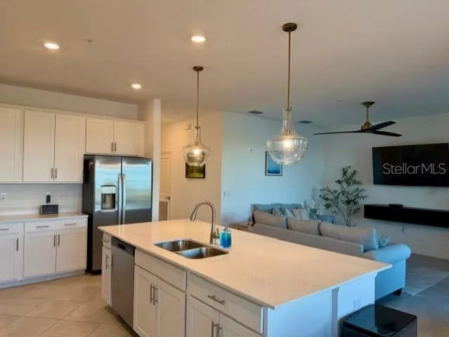 a kitchen with stainless steel appliances kitchen island granite countertop a sink a stove and a refrigerator