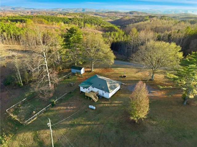 a front view of house with yard and trees in the background