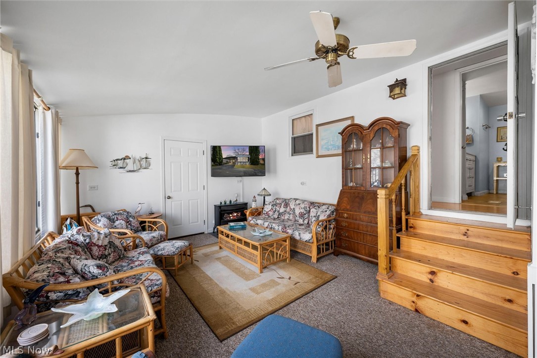 1623 Northeast Catawba Road, Unit 160 Port Clinton, OH 43452 - Photo 21 of 28 Three-season room with light carpet, ceiling fan and stairway