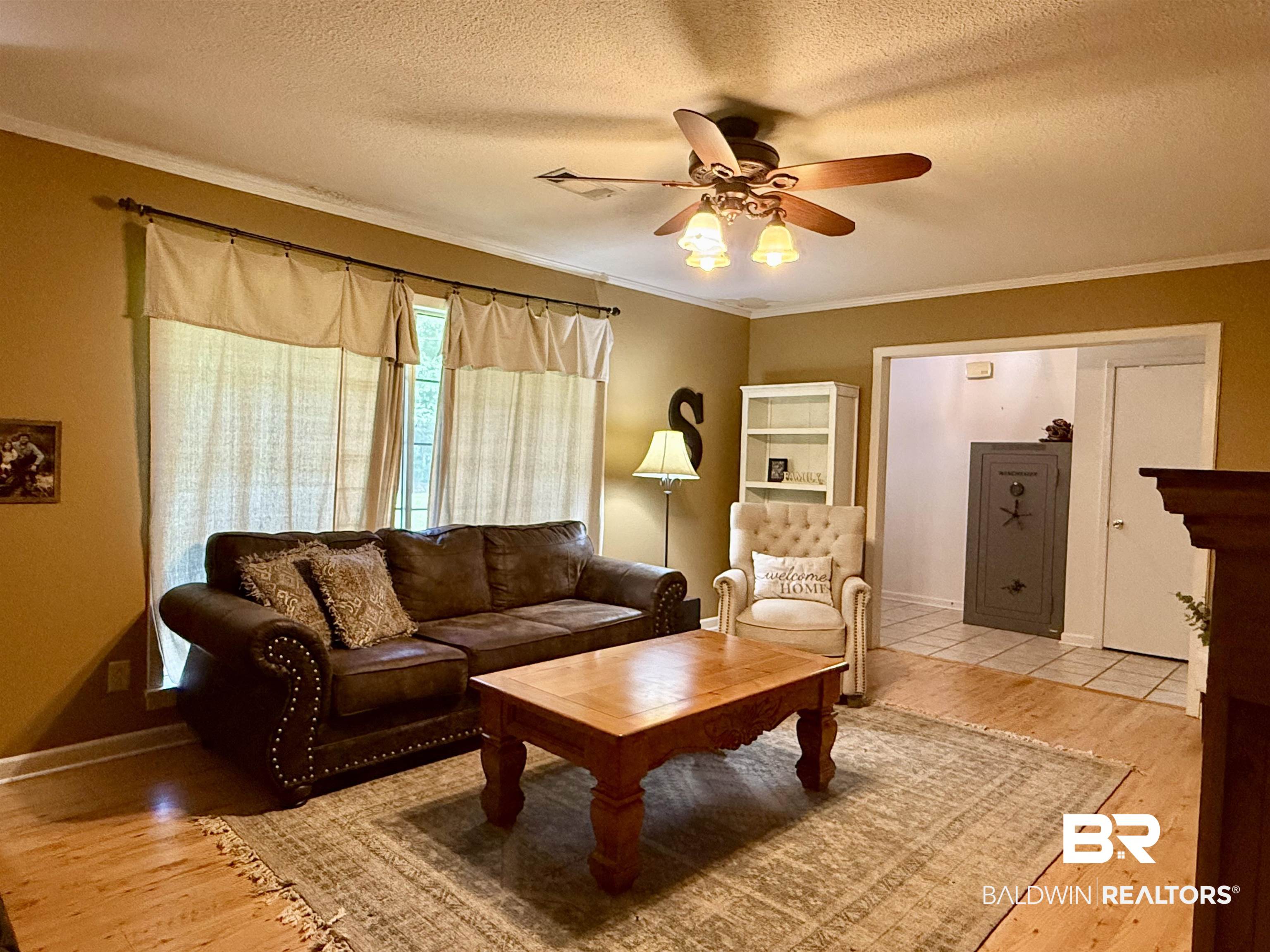 5971 Appleton Road Brewton, AL 36426 - Photo 4 of 23 Living area featuring ceiling fan, light wood-style floors, a textured ceiling, and ornamental molding