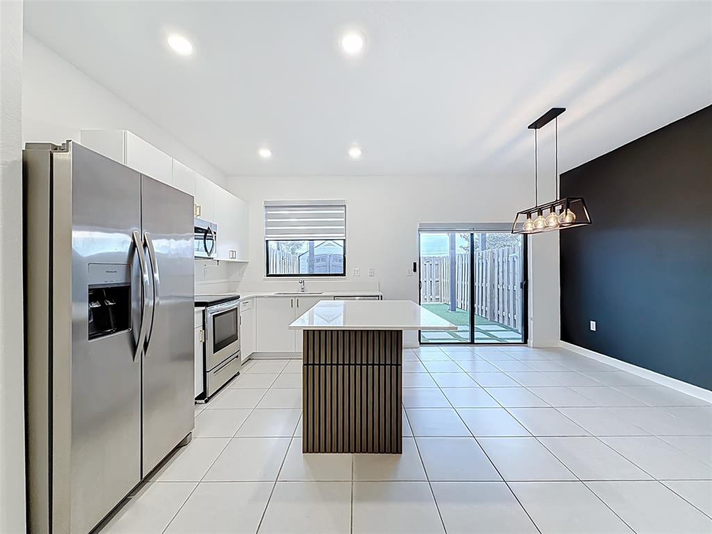 23513 Southwest 127th Place Homestead, FL 33032 - Photo 14 of 43 a kitchen with granite countertop a refrigerator and cabinets