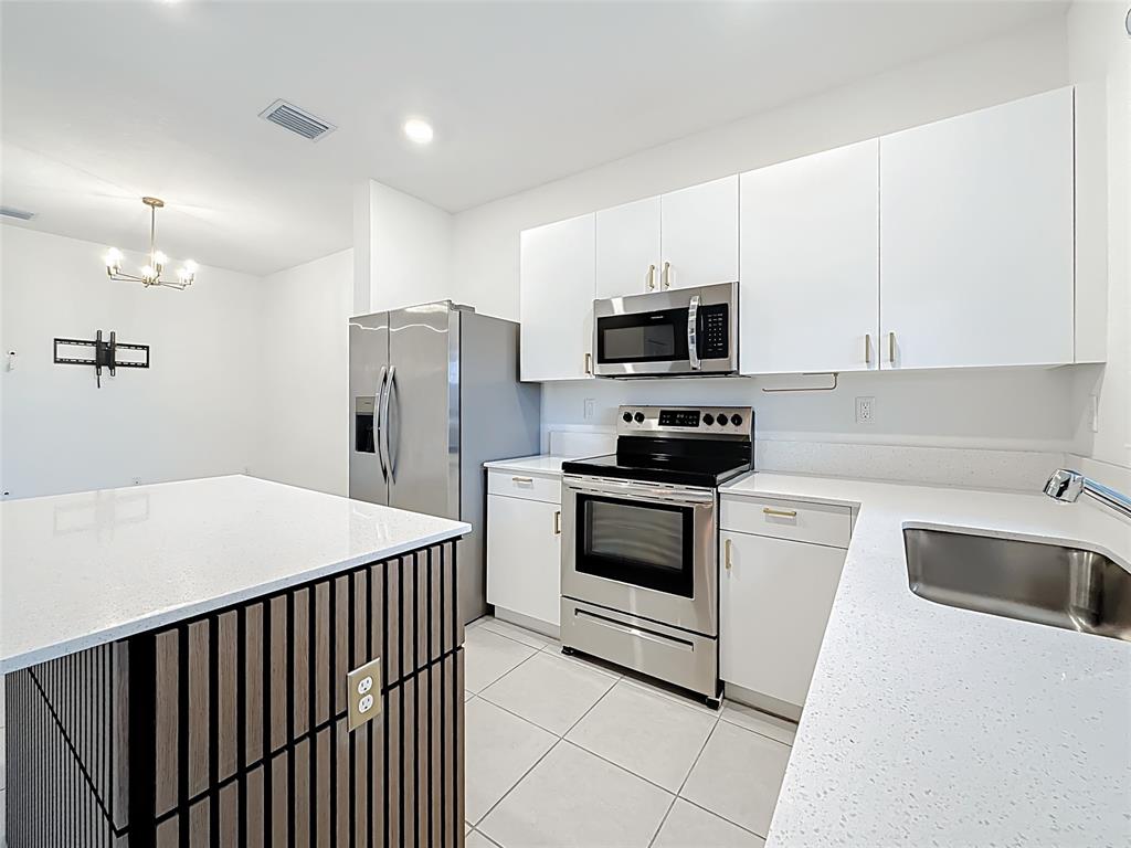 23513 Southwest 127th Place Homestead, FL 33032 - Photo 16 of 43 a kitchen with a sink a stove and refrigerator