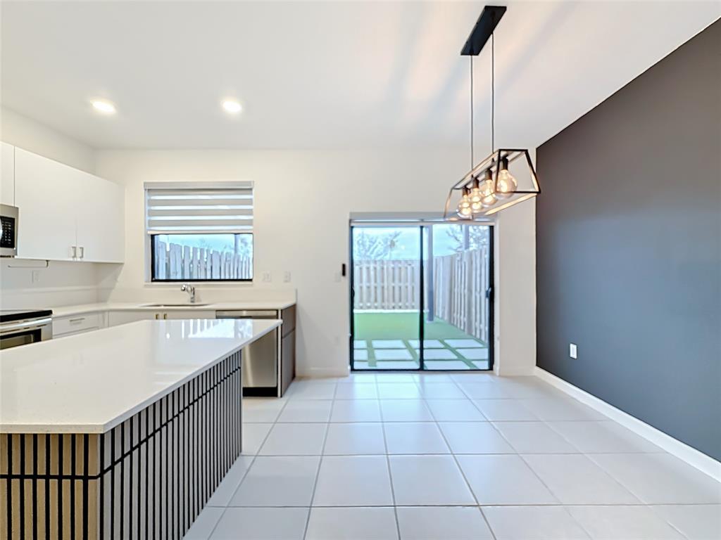 23513 Southwest 127th Place Homestead, FL 33032 - Photo 20 of 43 a kitchen with stainless steel appliances granite countertop a sink and a refrigerator