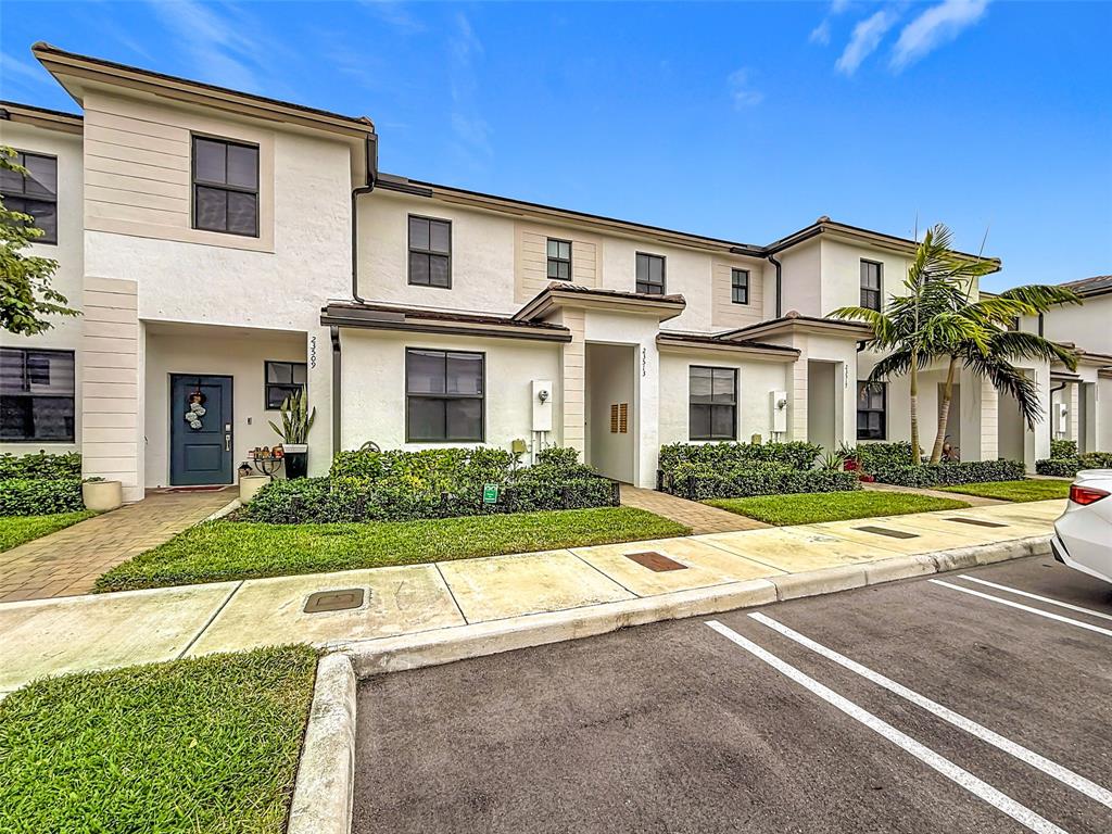 23513 Southwest 127th Place Homestead, FL 33032 - Photo 6 of 43 a front view of a house with a yard and potted plants