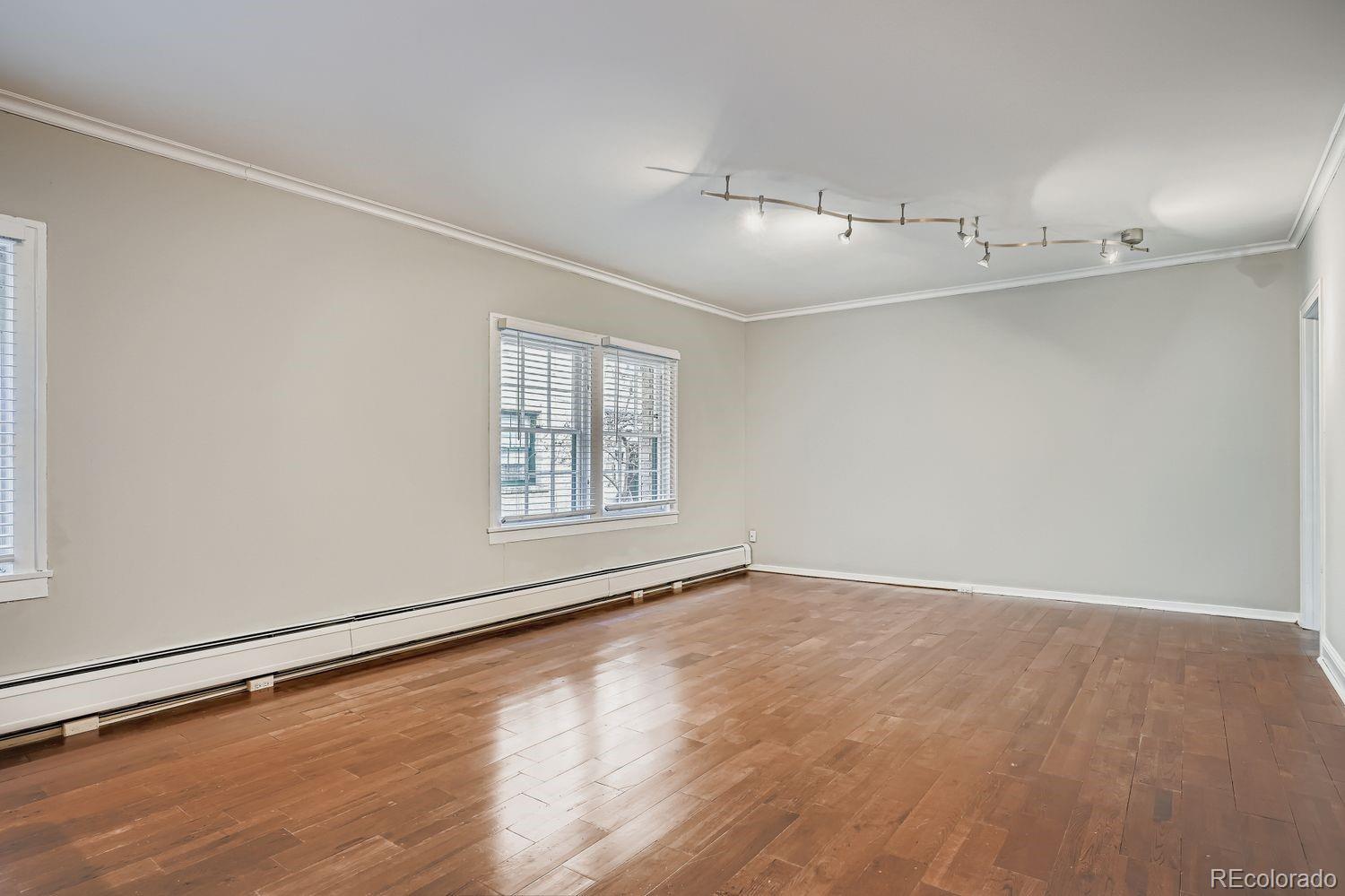 960 Sherman Street, Unit 1B Denver, CO 80203 - Photo 12 of 25 an empty room with wooden floor and windows