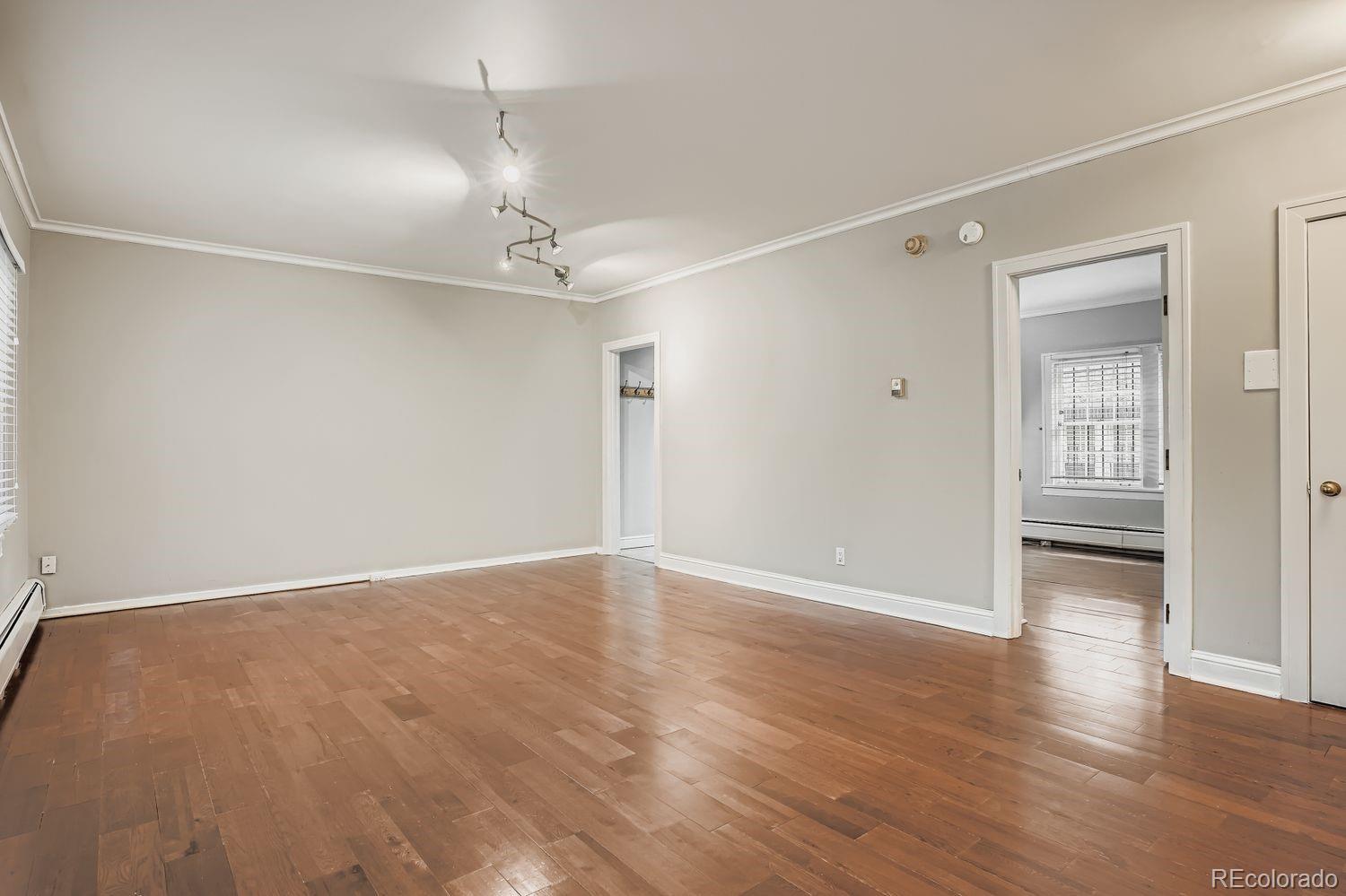 960 Sherman Street, Unit 1B Denver, CO 80203 - Photo 14 of 25 a view of an empty room with wooden floor