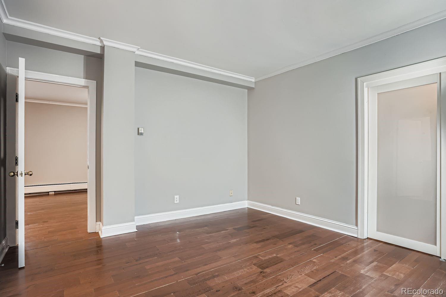 960 Sherman Street, Unit 1B Denver, CO 80203 - Photo 17 of 25 a view of an empty room with wooden floor and closet