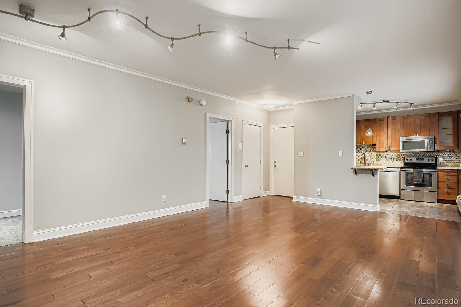 960 Sherman Street, Unit 1B Denver, CO 80203 - Photo 8 of 25 a view of a kitchen with a sink and a refrigerator