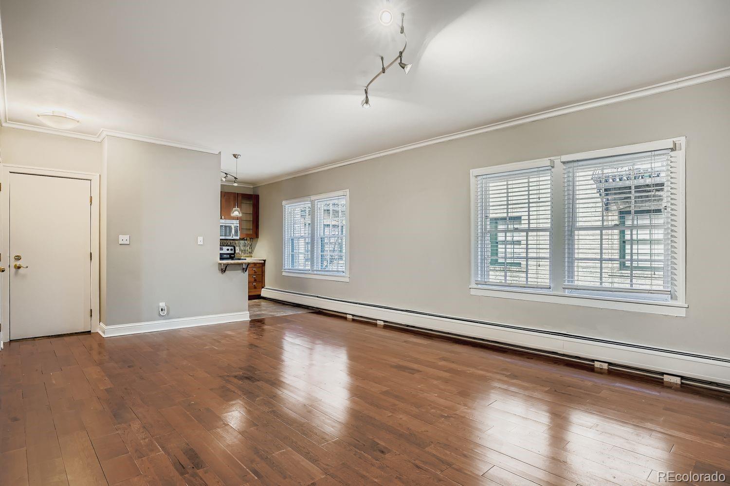 960 Sherman Street, Unit 1B Denver, CO 80203 - Photo 10 of 25 an empty room with wooden floor and windows