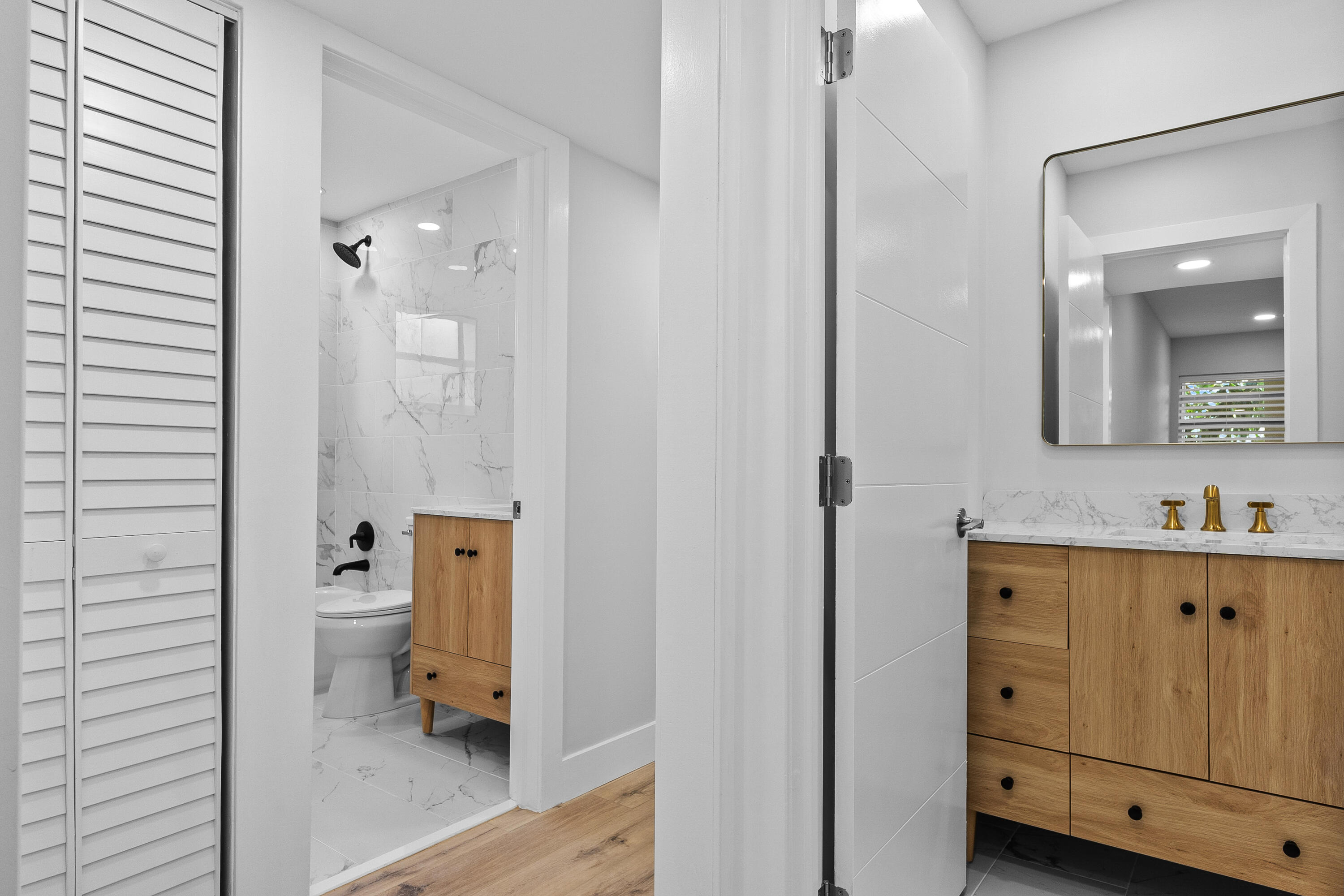 314 Monaco Boulevard, Unit G Delray Beach, FL 33446 - Photo 19 of 26 a en suite bathroom with a toilet sink and mirror