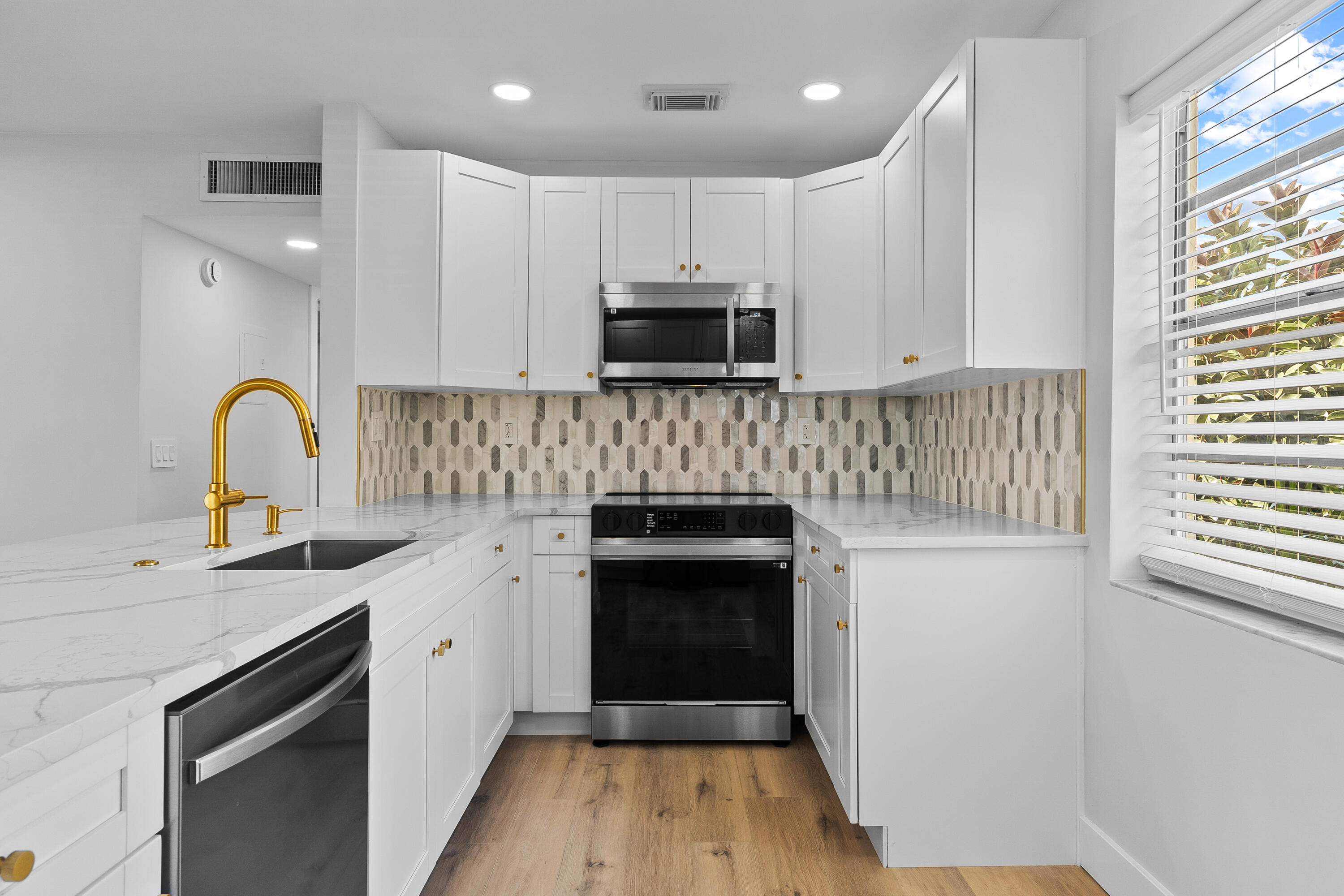 314 Monaco Boulevard, Unit G Delray Beach, FL 33446 - Photo 7 of 26 a kitchen with a sink a stove and cabinets