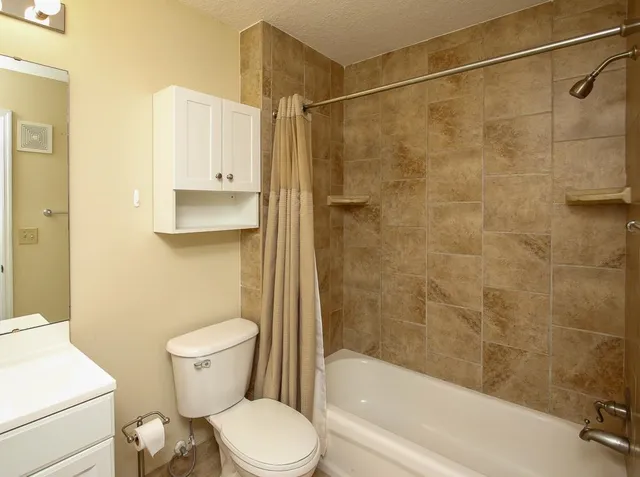 a white toilet sitting next to a bath tub and a shower