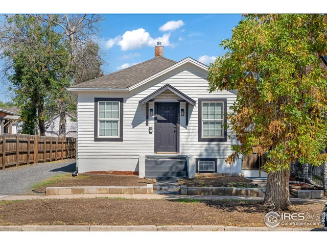a front view of a house with a tree