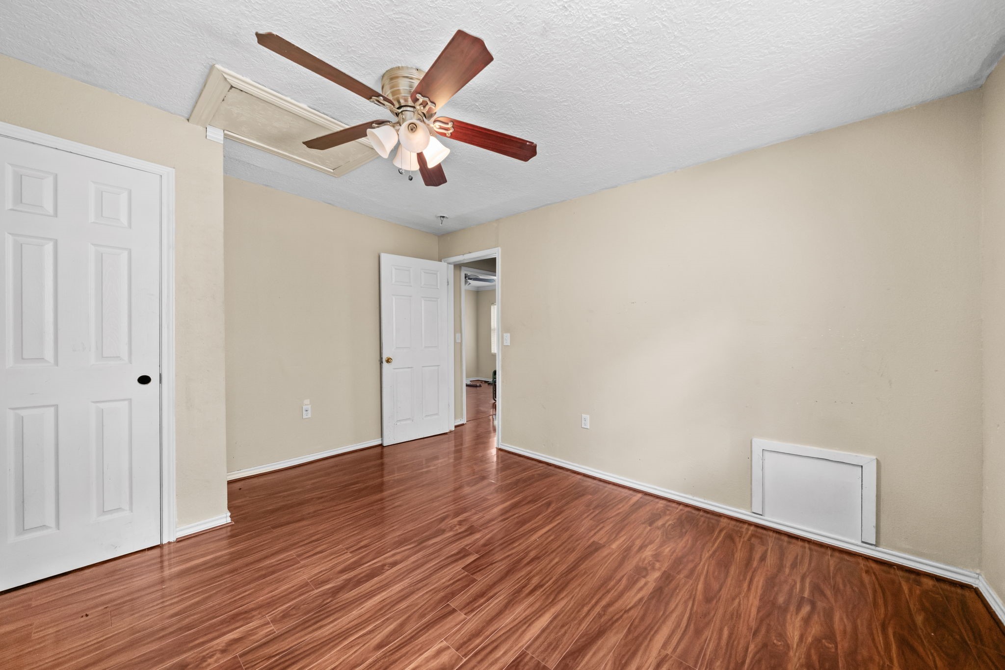 1814 Mansfield Street Houston, TX 77091 - Photo 18 of 29 an empty room with wooden floor and ceiling fan