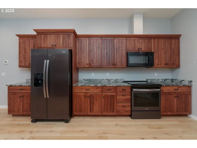 a kitchen with stainless steel appliances granite countertop a refrigerator and a sink