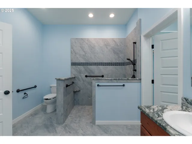 a bathroom with a granite countertop sink toilet and shower