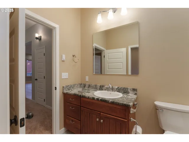 a bathroom with a granite countertop sink a mirror and a shower