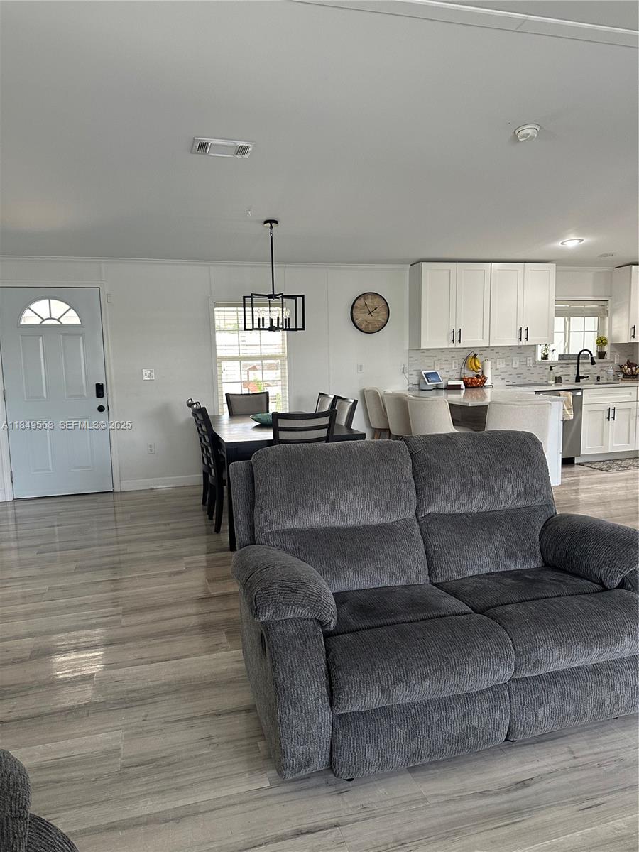 1570 Southwest 64th Way Boca Raton, FL 33428 - Photo 13 of 24 a living room with furniture and a clock