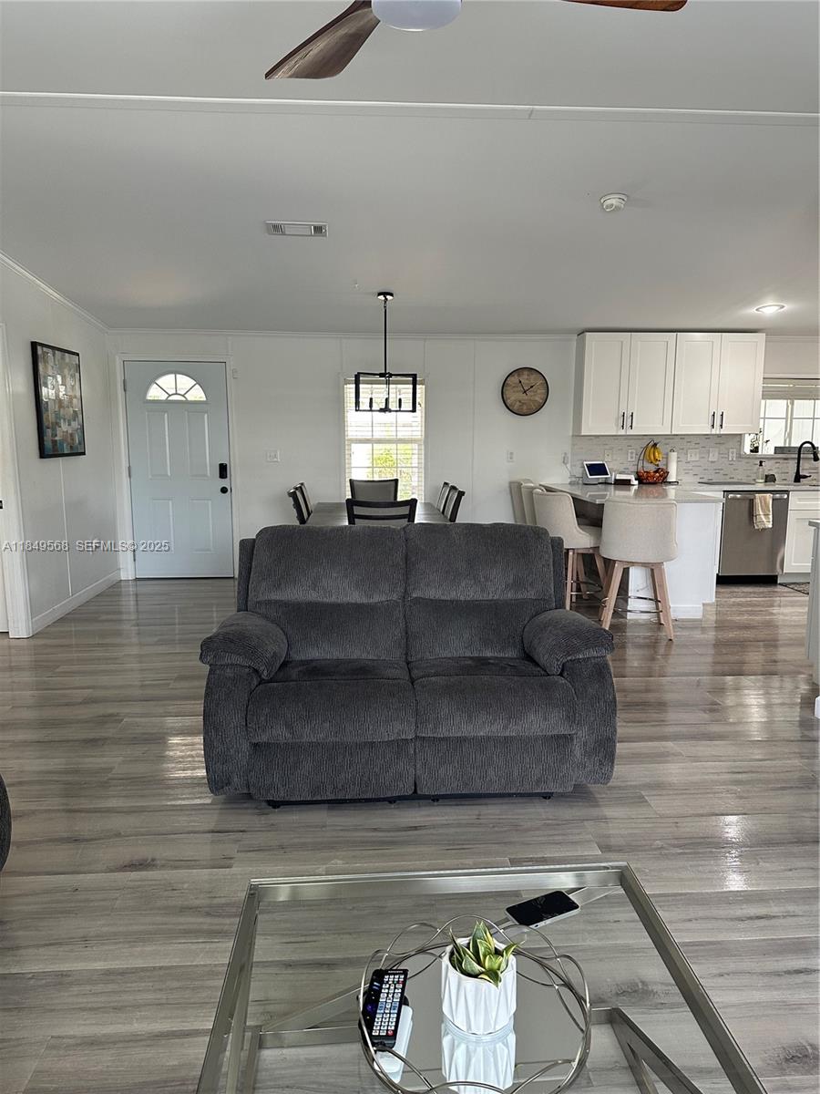 1570 Southwest 64th Way Boca Raton, FL 33428 - Photo 14 of 24 a living room with couches and kitchen view with wooden floor