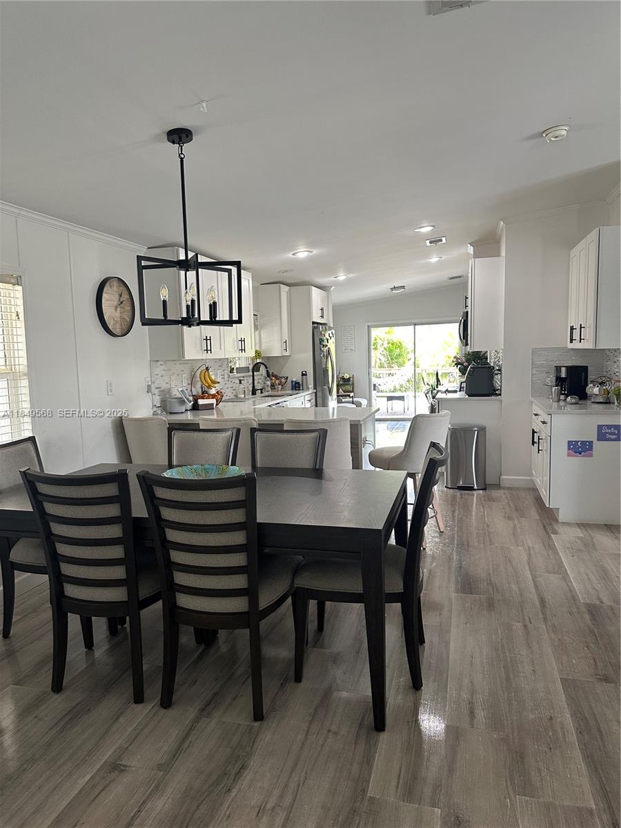 1570 Southwest 64th Way Boca Raton, FL 33428 - Photo 16 of 24 a view of a dining room with furniture wooden floor and chandelier