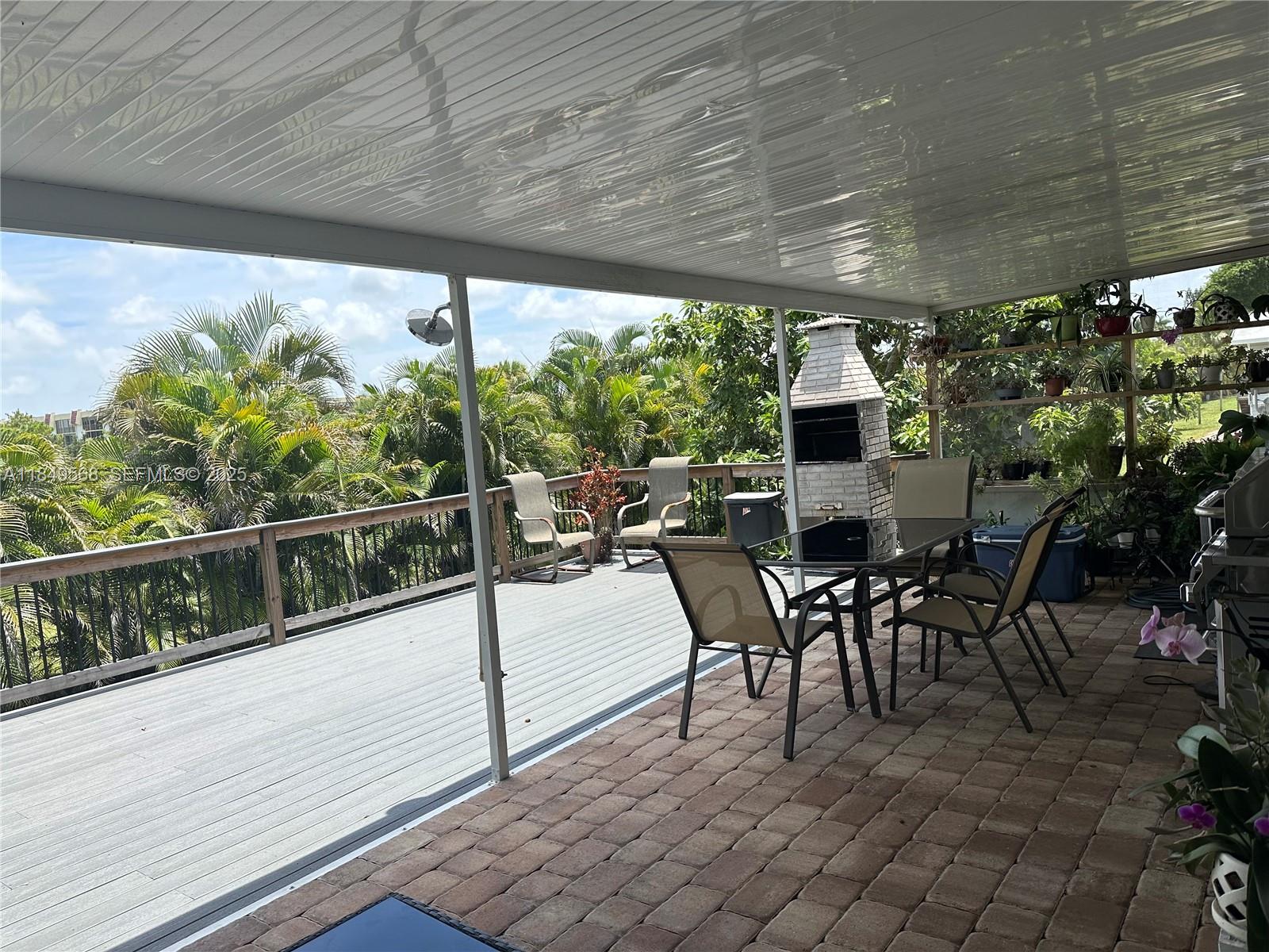 1570 Southwest 64th Way Boca Raton, FL 33428 - Photo 20 of 24 a view of a patio with table and chairs potted plants with wooden floor