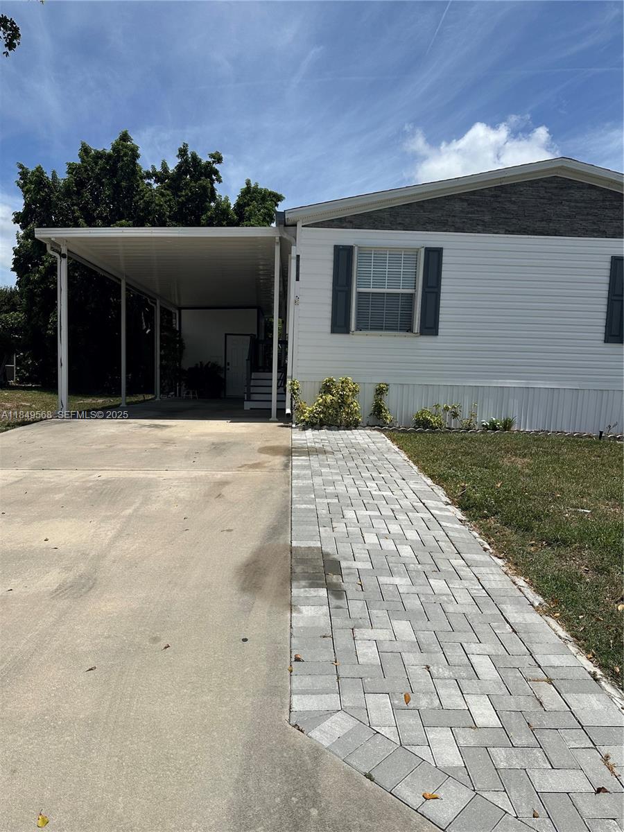 1570 Southwest 64th Way Boca Raton, FL 33428 - Photo 3 of 24 a front view of a house with a yard
