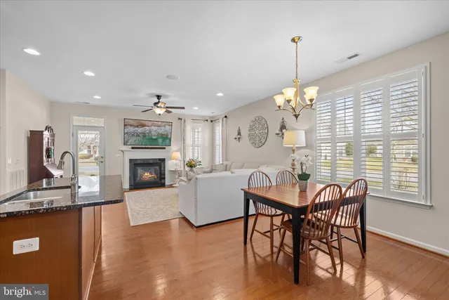 a kitchen with granite countertop a table chairs stove and wooden floor