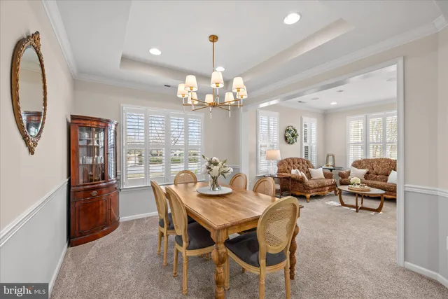 a view of a dining room with furniture a chandelier and wooden floor
