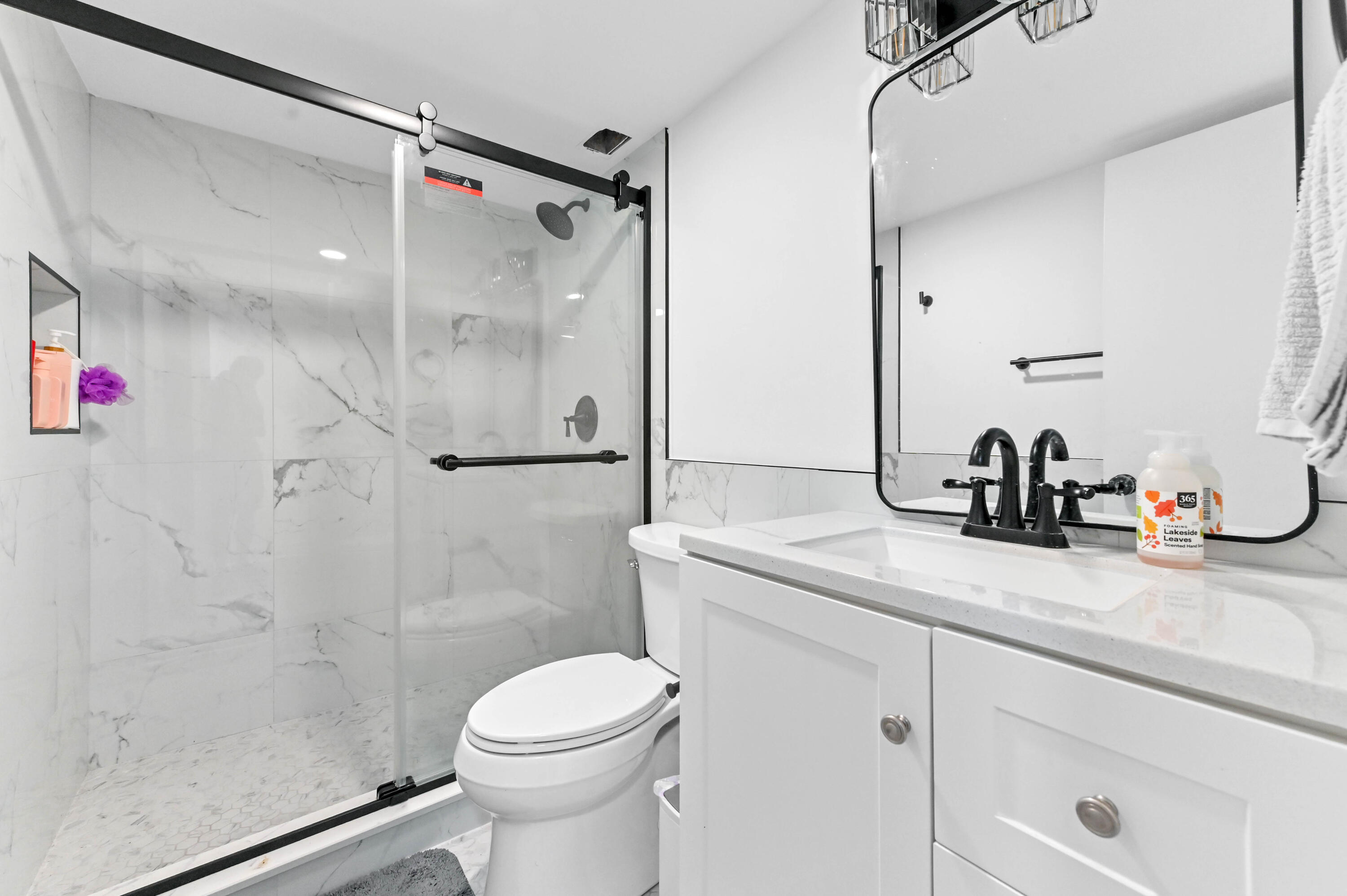 5700 Northwest 2nd Avenue, Unit 211 Boca Raton, FL 33487 - Photo 13 of 29 a bathroom with a shower sink vanity mirror and toilet