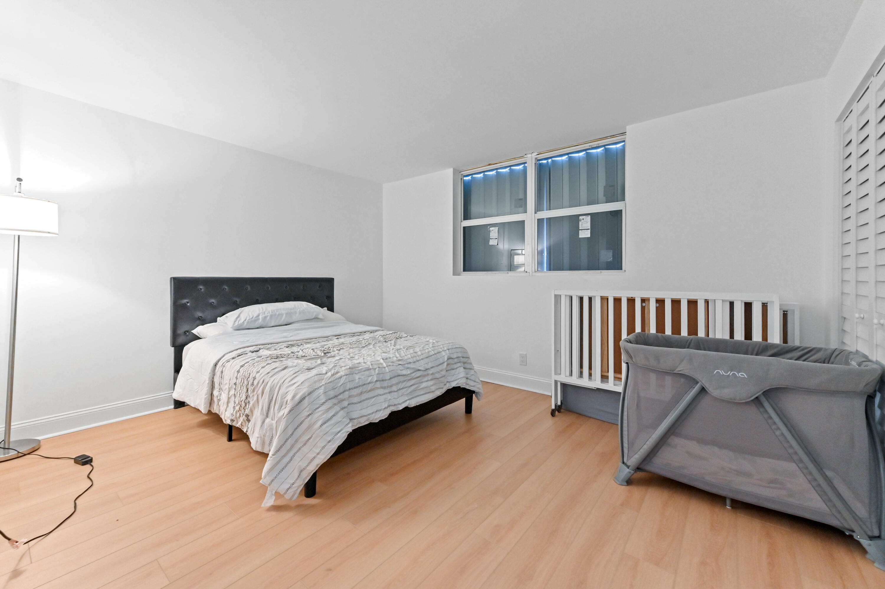 5700 Northwest 2nd Avenue, Unit 211 Boca Raton, FL 33487 - Photo 14 of 29 a bedroom with a bed and wooden floor