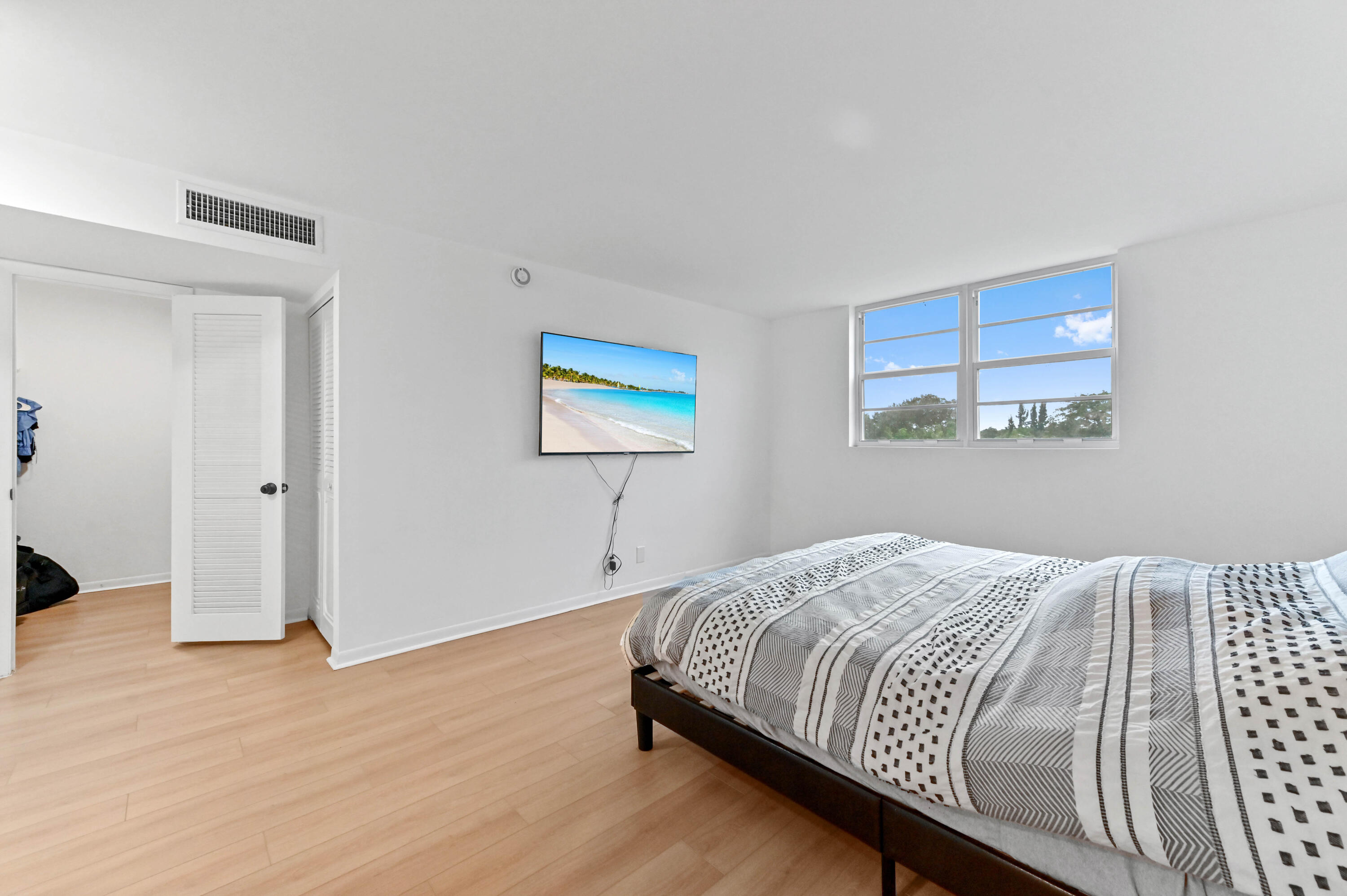 5700 Northwest 2nd Avenue, Unit 211 Boca Raton, FL 33487 - Photo 19 of 29 a bedroom with a bed and painting on the wall