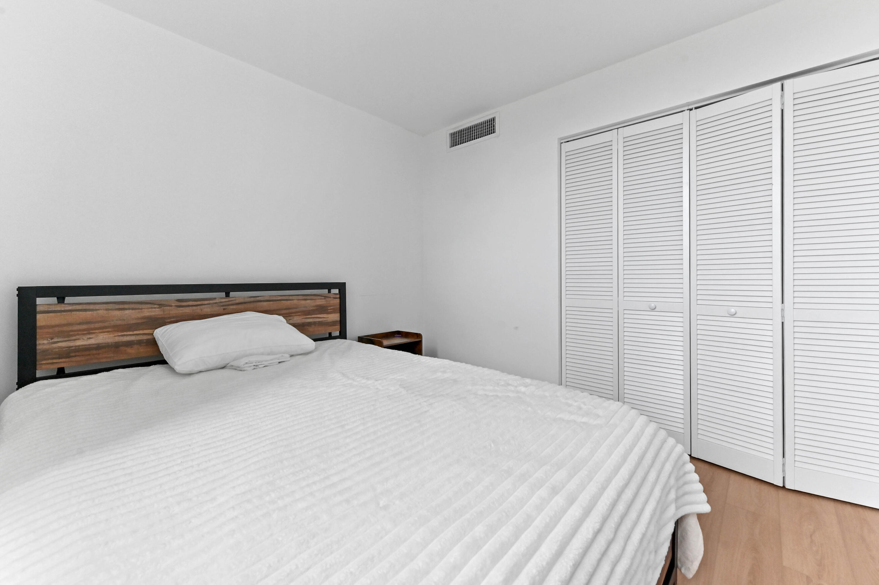 5700 Northwest 2nd Avenue, Unit 211 Boca Raton, FL 33487 - Photo 24 of 29 a bedroom with a bed and wooden floor