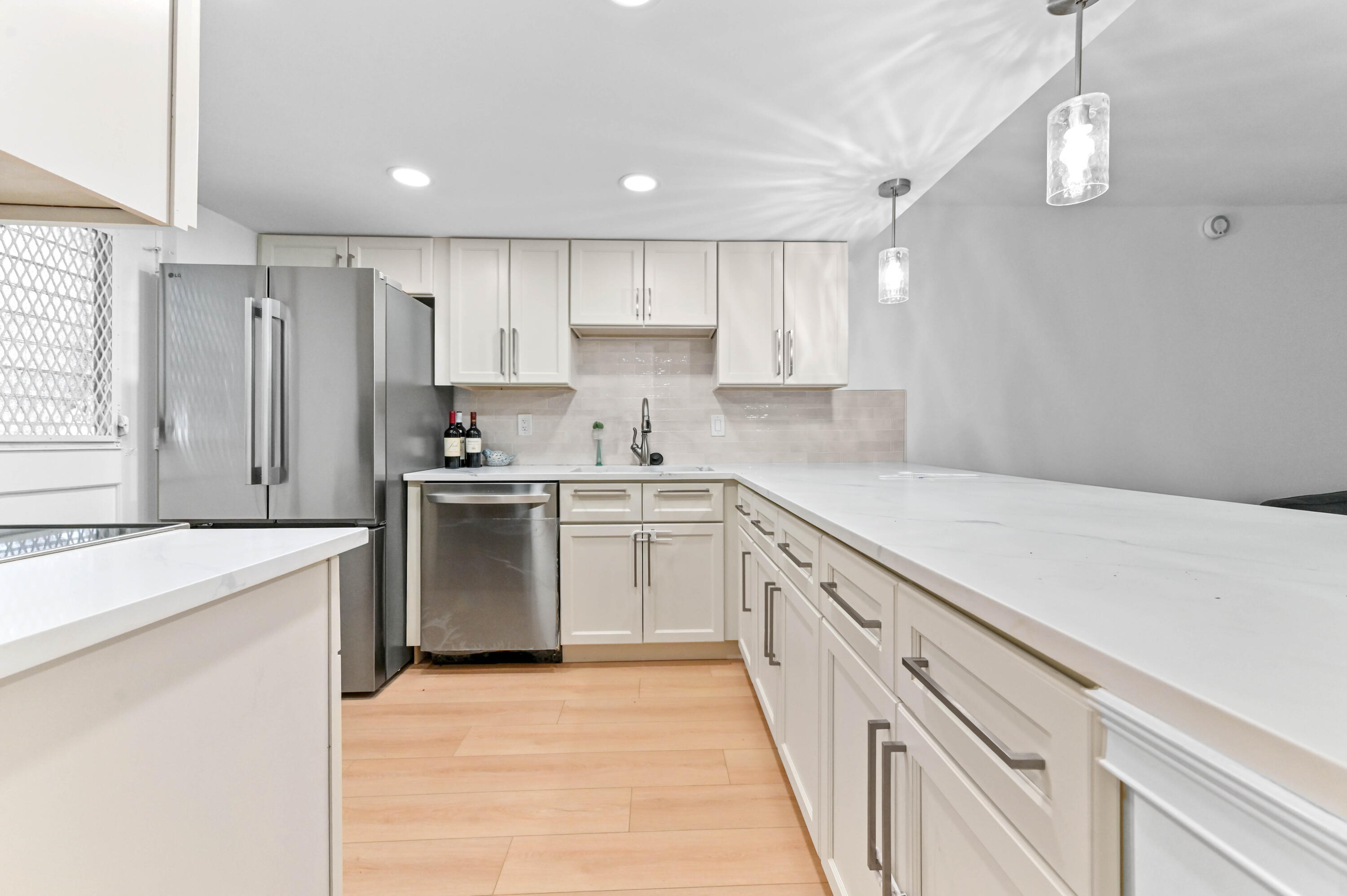 5700 Northwest 2nd Avenue, Unit 211 Boca Raton, FL 33487 - Photo 5 of 29 a kitchen with granite countertop white cabinets and white appliances