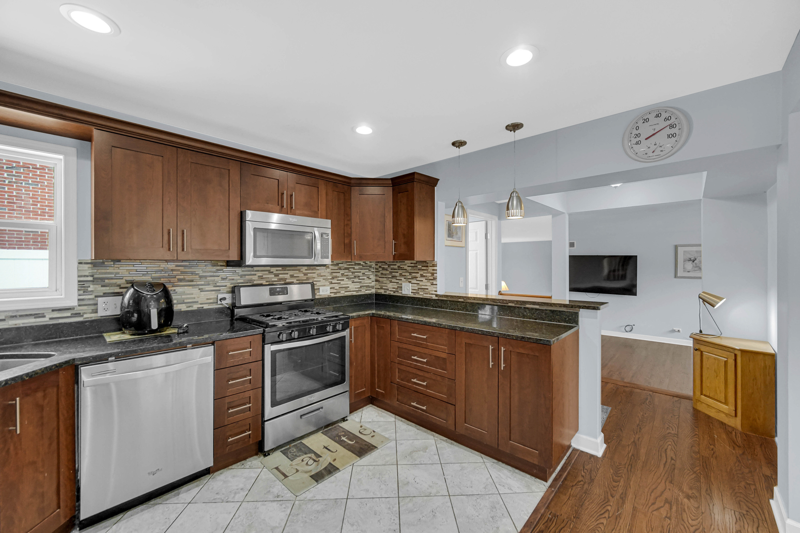 6330 107th Street Chicago Ridge, IL 60415 - Photo 13 of 27 a kitchen with stainless steel appliances granite countertop wooden cabinets a stove top oven a sink and dishwasher with wooden floor