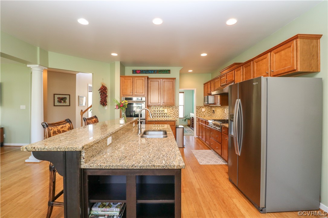 4628 Allenbend Road Glen Allen, VA 23060 - Photo 12 of 50 a kitchen with granite countertop kitchen island stainless steel appliances a refrigerator a stove a sink a dining table and chairs with wooden floor