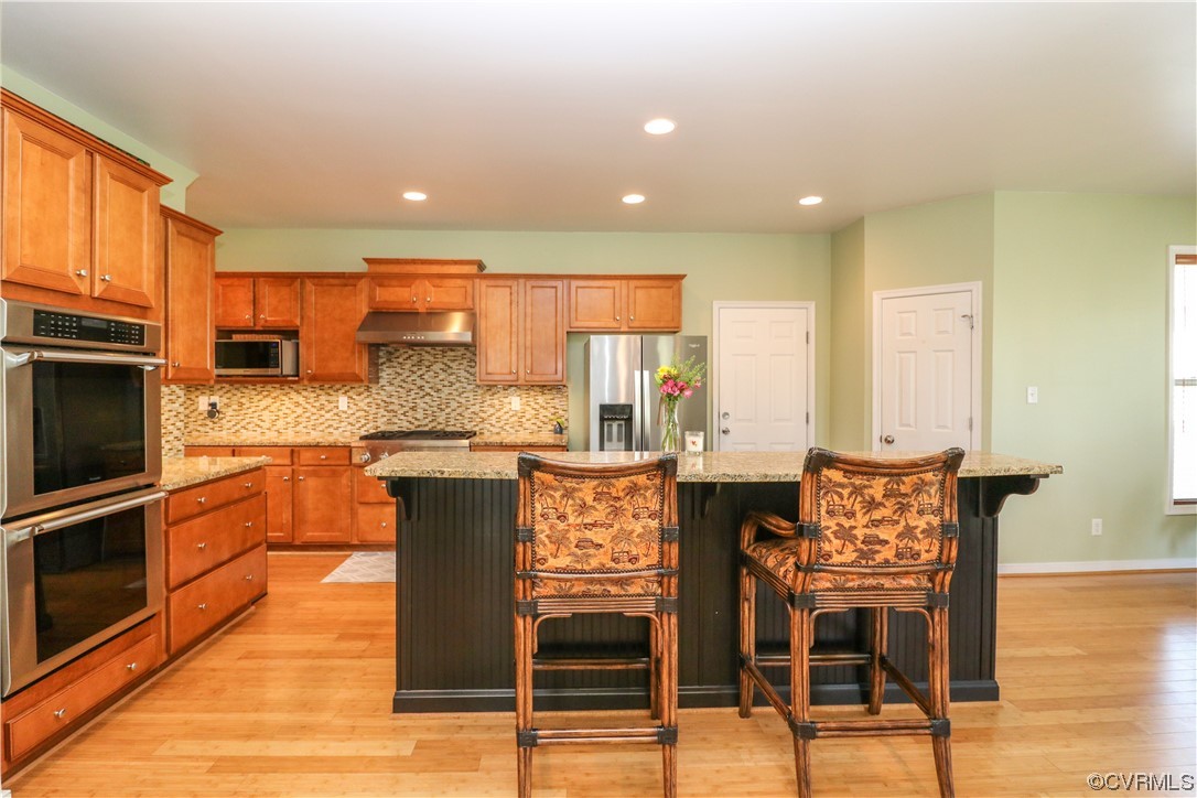 4628 Allenbend Road Glen Allen, VA 23060 - Photo 10 of 50 a kitchen with stainless steel appliances granite countertop a stove top oven a sink a dining table and chairs with wooden floor